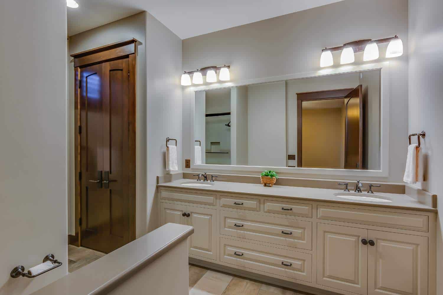 View of white bathroom mirrors, cabinets, and sinks