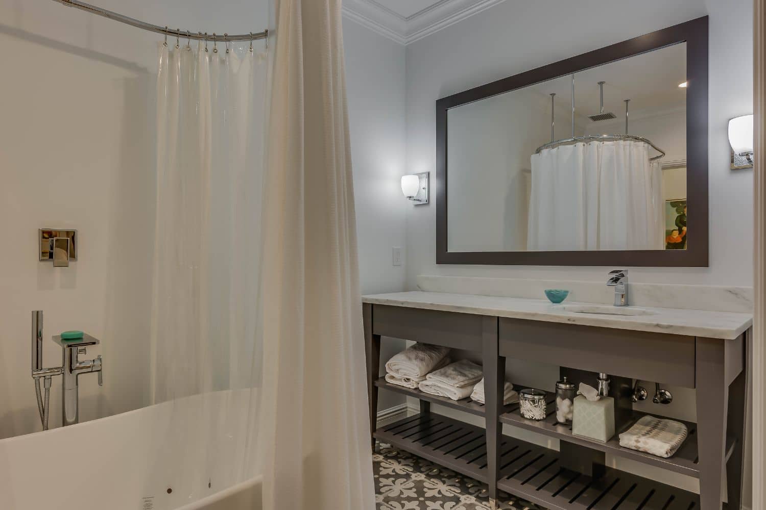 View of shower from bathroom with custom sink storage space