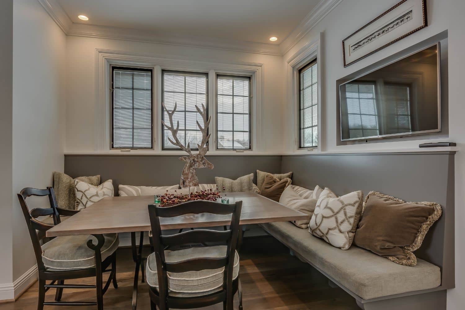 Custom kitchen eating nook in Granger Indiana with bench, pillows, and two chairs