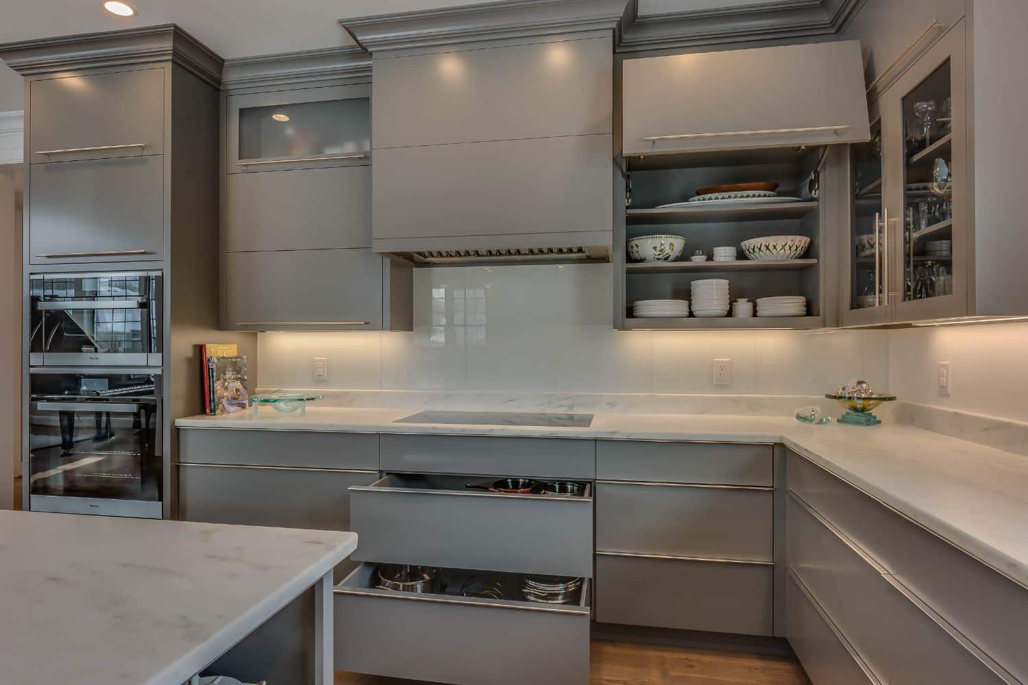 View of slide out kitchen drawers in Granger Indiana with gray color and stove hood