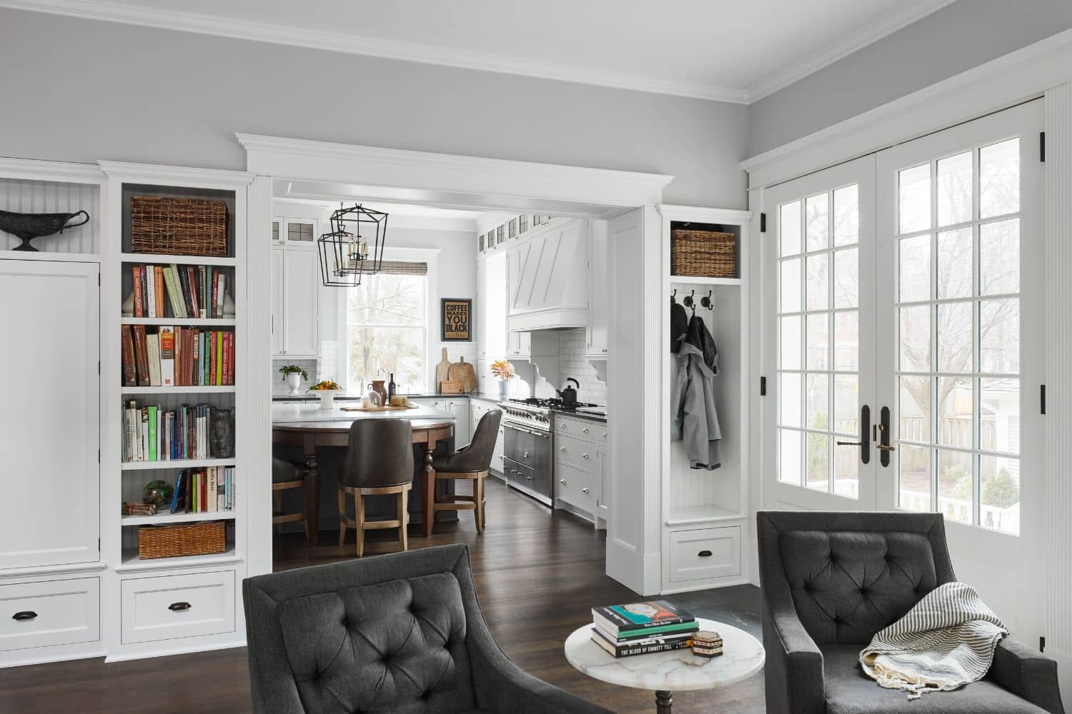 View of custom kitchen cabinets and library storage space from living room