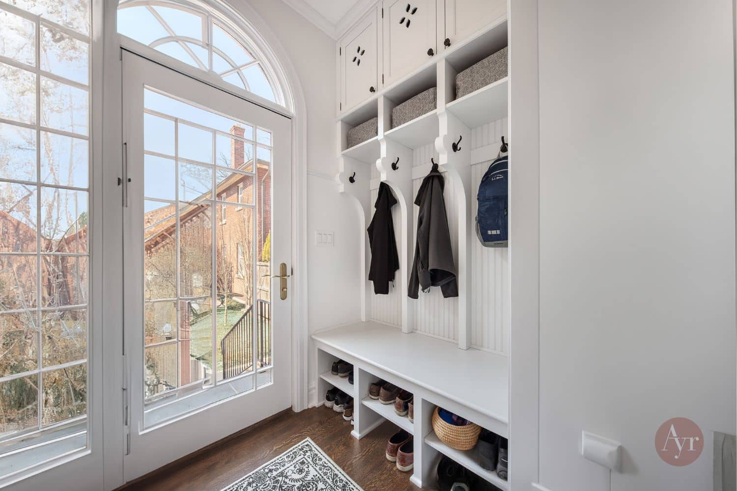 mudroom cabinetry in evanston il with three cubbies and spots for coats and shoe organizers