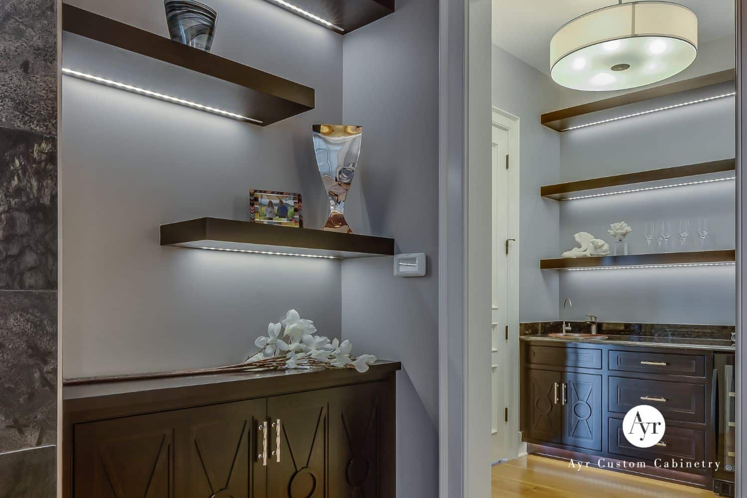 Custom floating shelves with lighting and cabinets